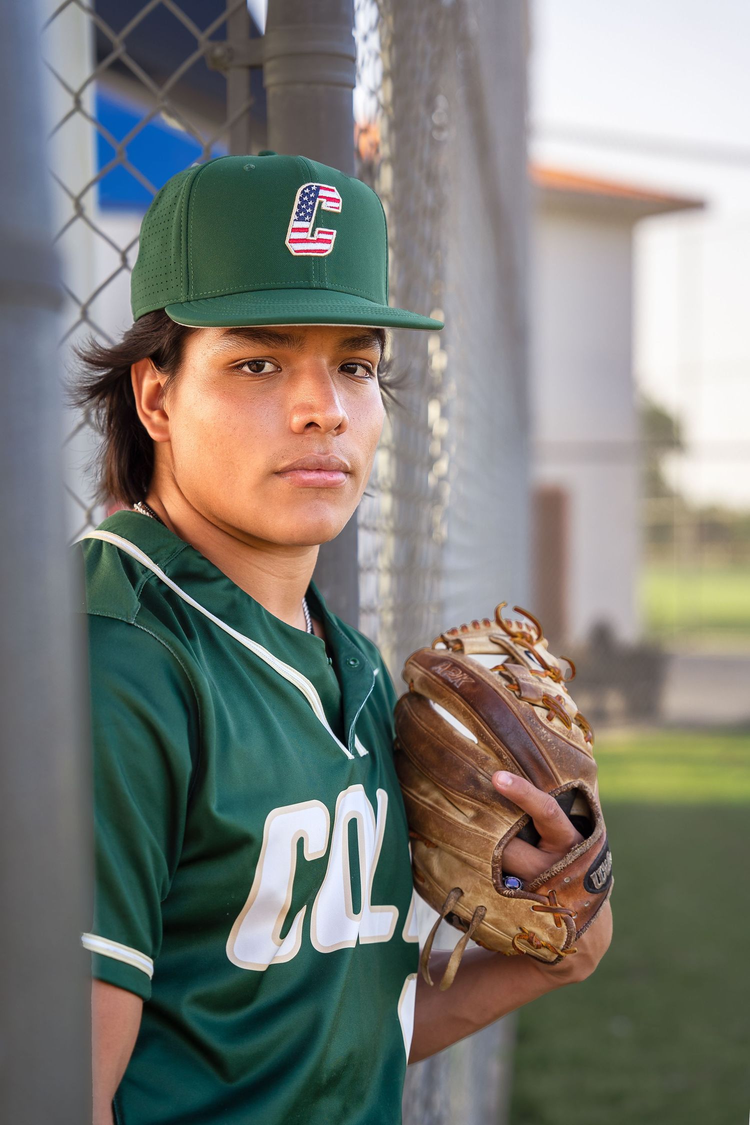 high school senior boy wearing baseball jersey, baseball hat and mitt in San Antonio, Texas