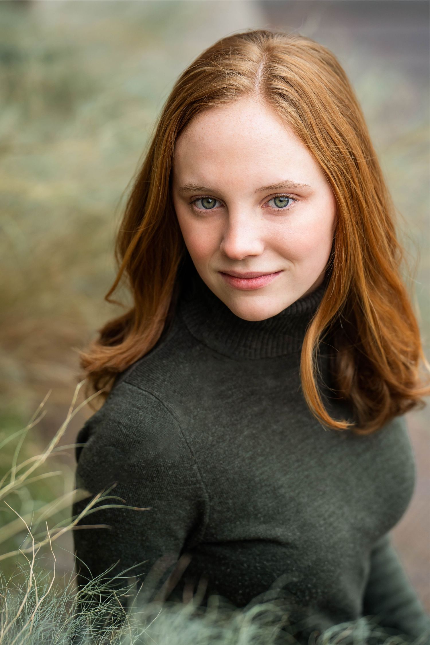 portrait of high school senior girl wearing green sweater near green foliage at the Historic Pearl in San Antonio