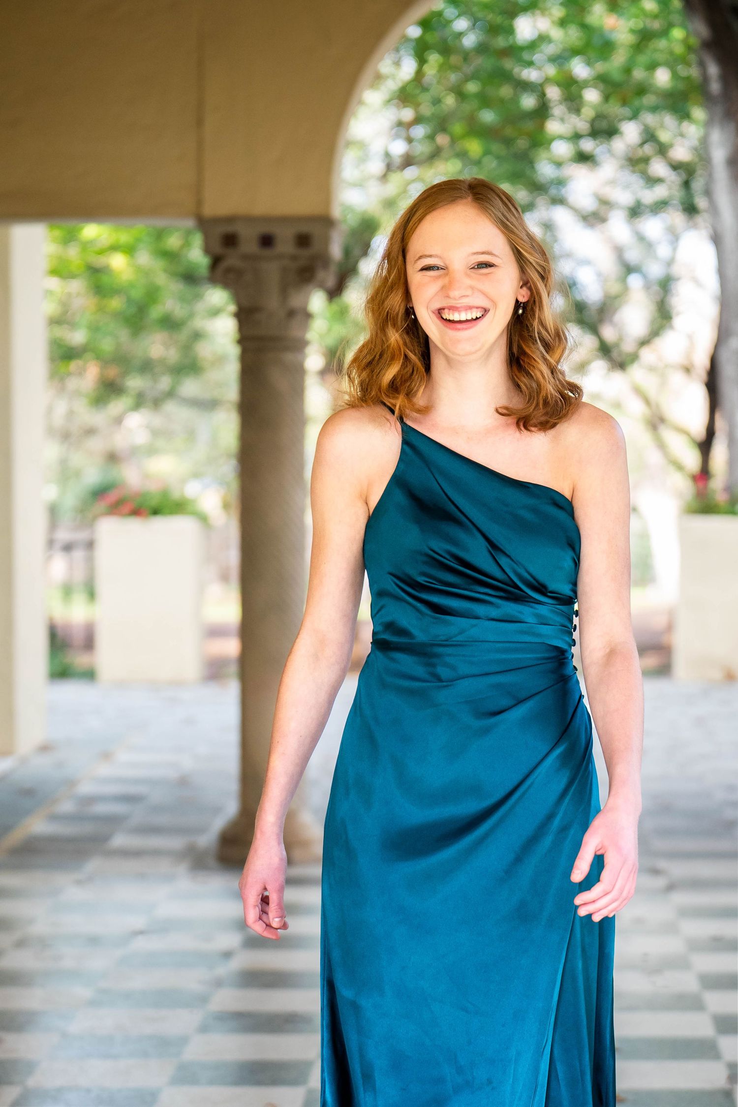 high school girl in green formal dress walking across porch laughing at Landa Library