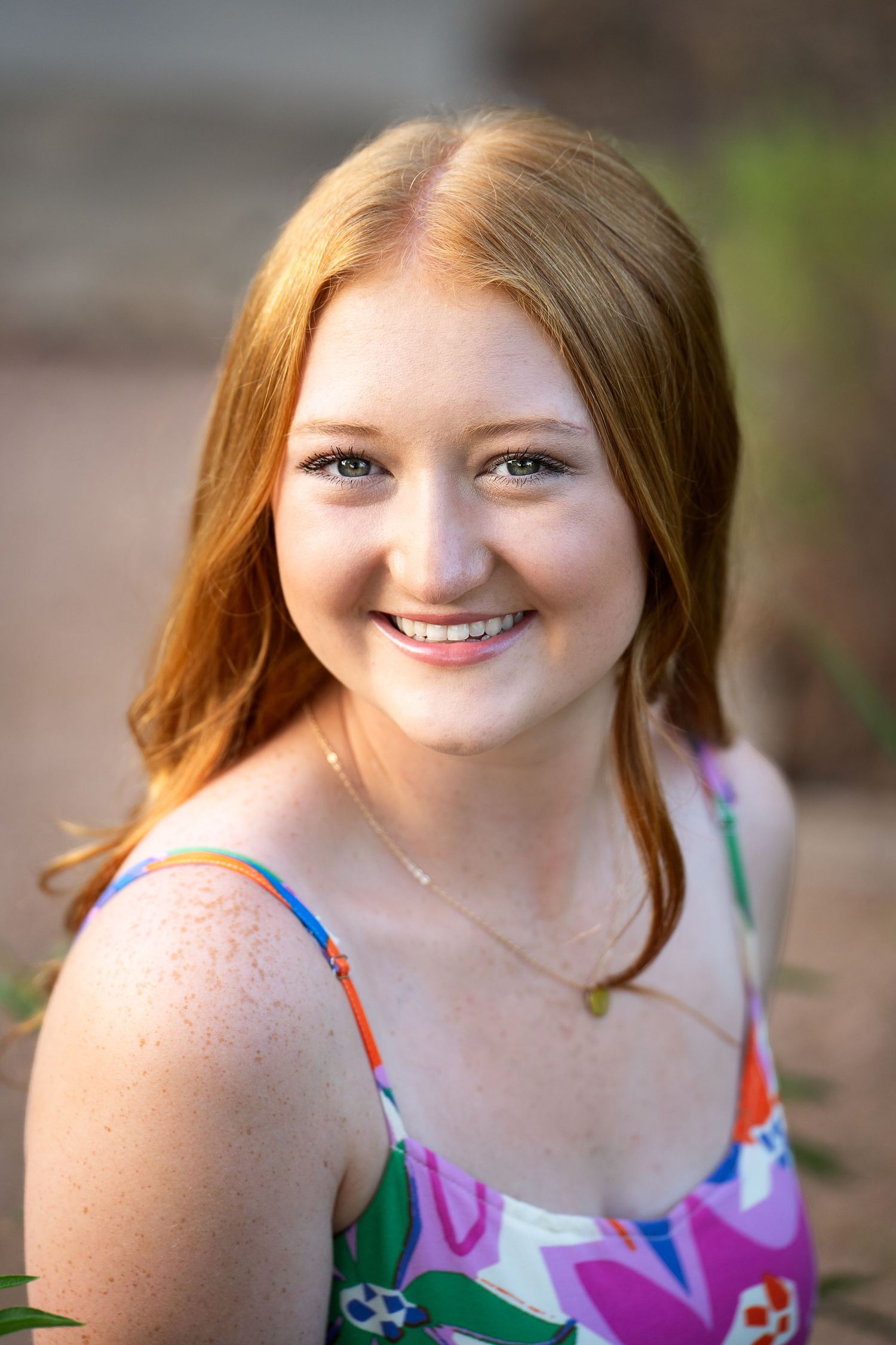 portrait of a high school senior girl wearing a floral sundress in Landa Gardens at Landa Library