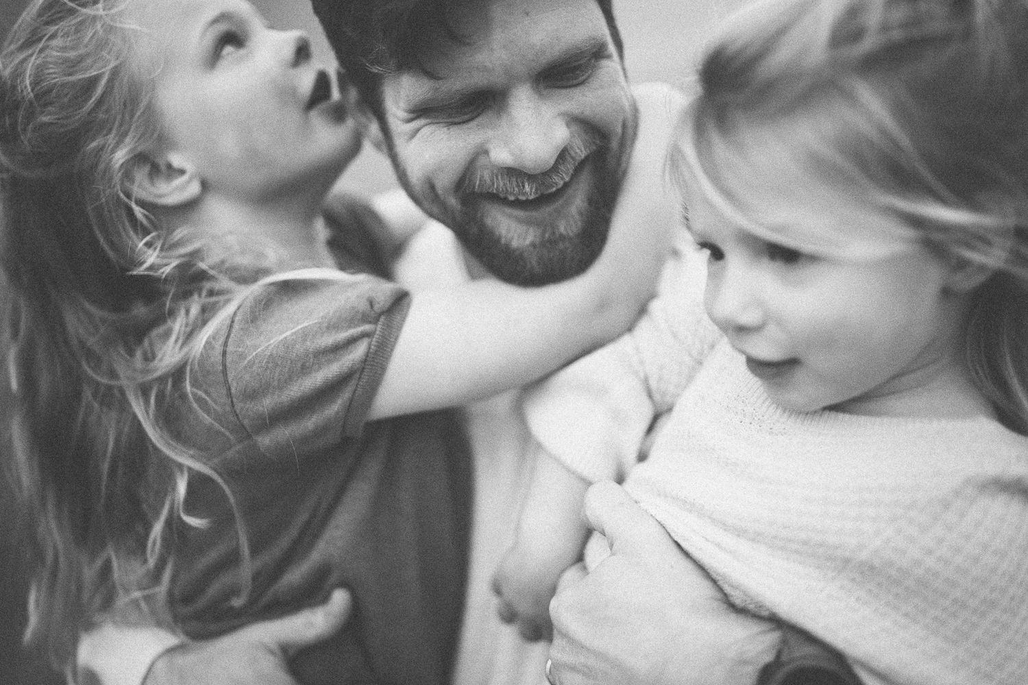 A candid black and white family portrait filled with laughter and joy.