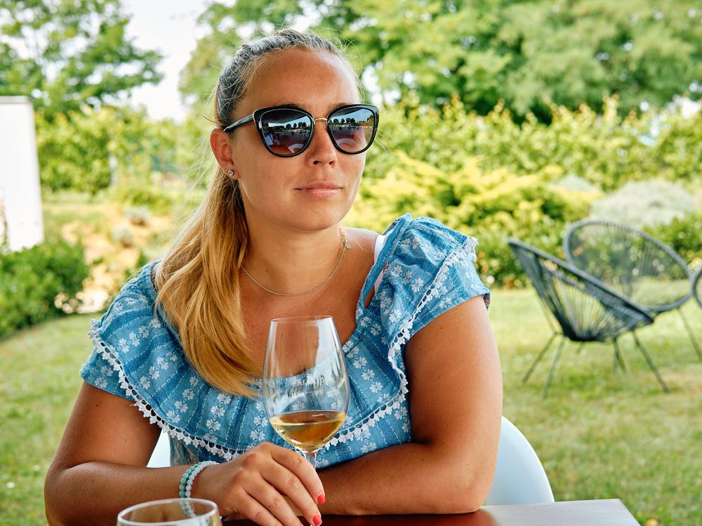 Summer outdoor wine tasting scene in garden setting.
