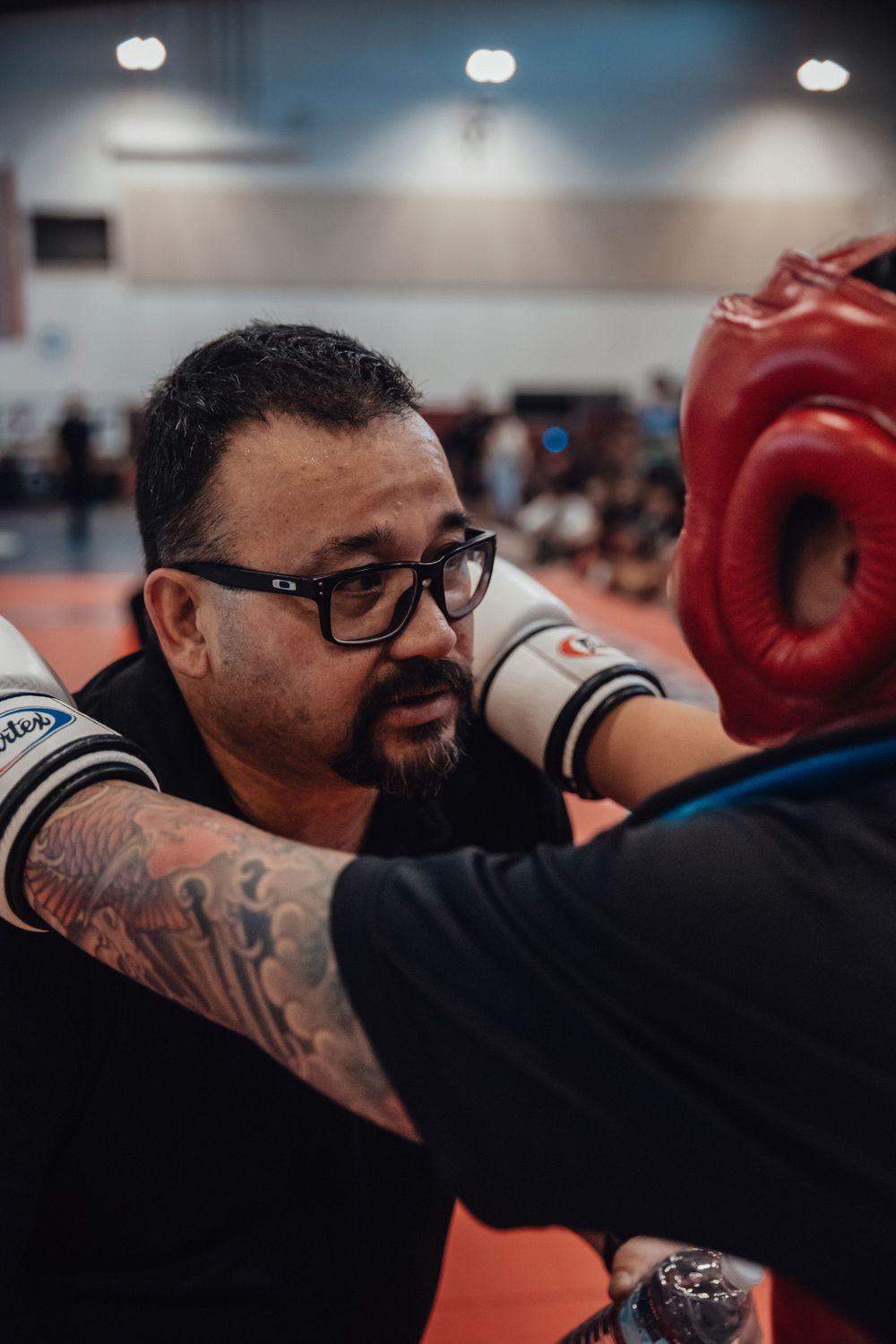 Instructor demonstrating boxing techniques with protective headgear during training session.