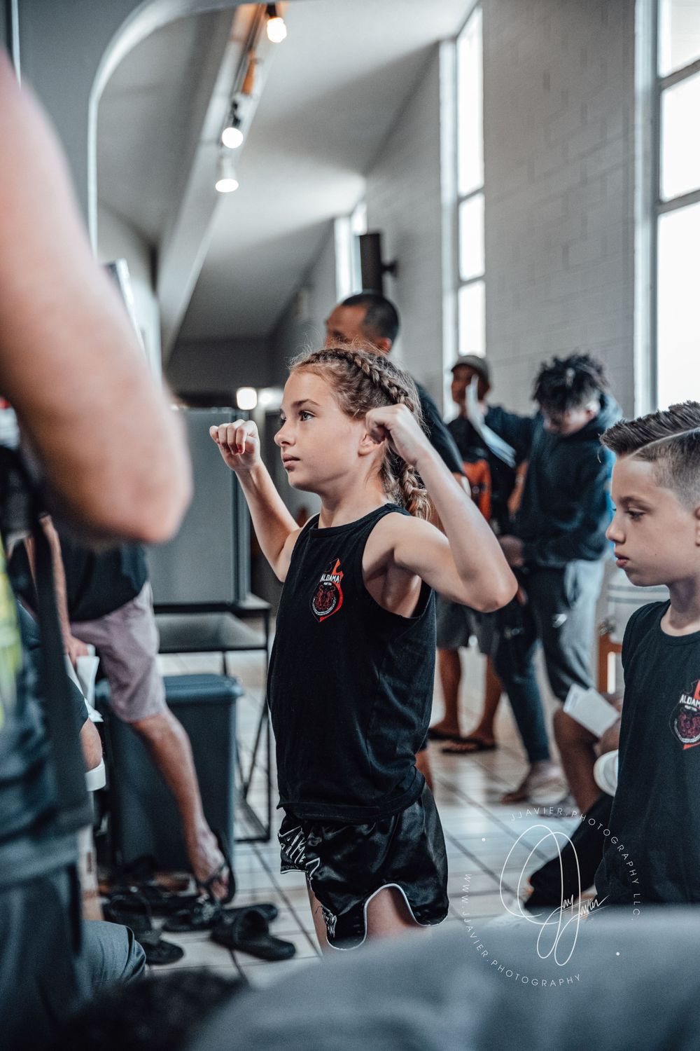 Athletes training in a bright indoor martial arts facility during a group session.