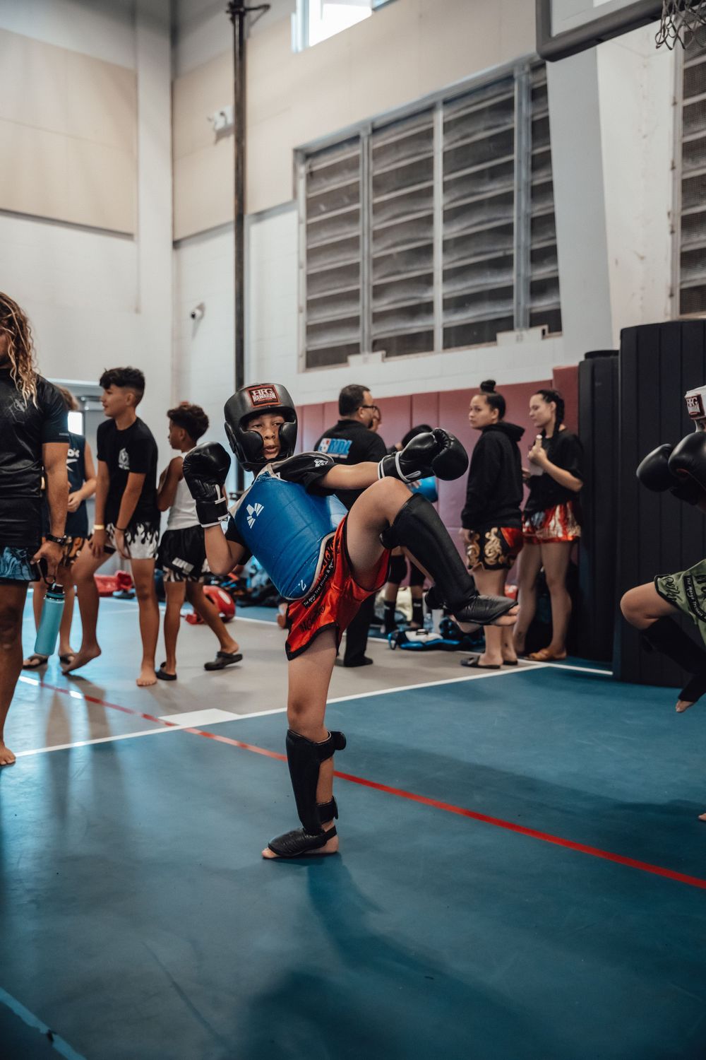 Group of athletes performing stretching exercises in a gymnasium.