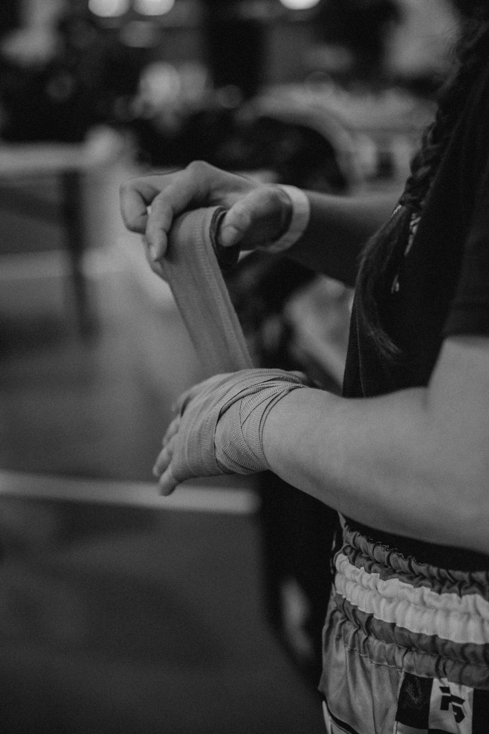Close-up of hands wrapping boxing tape during martial arts preparation.