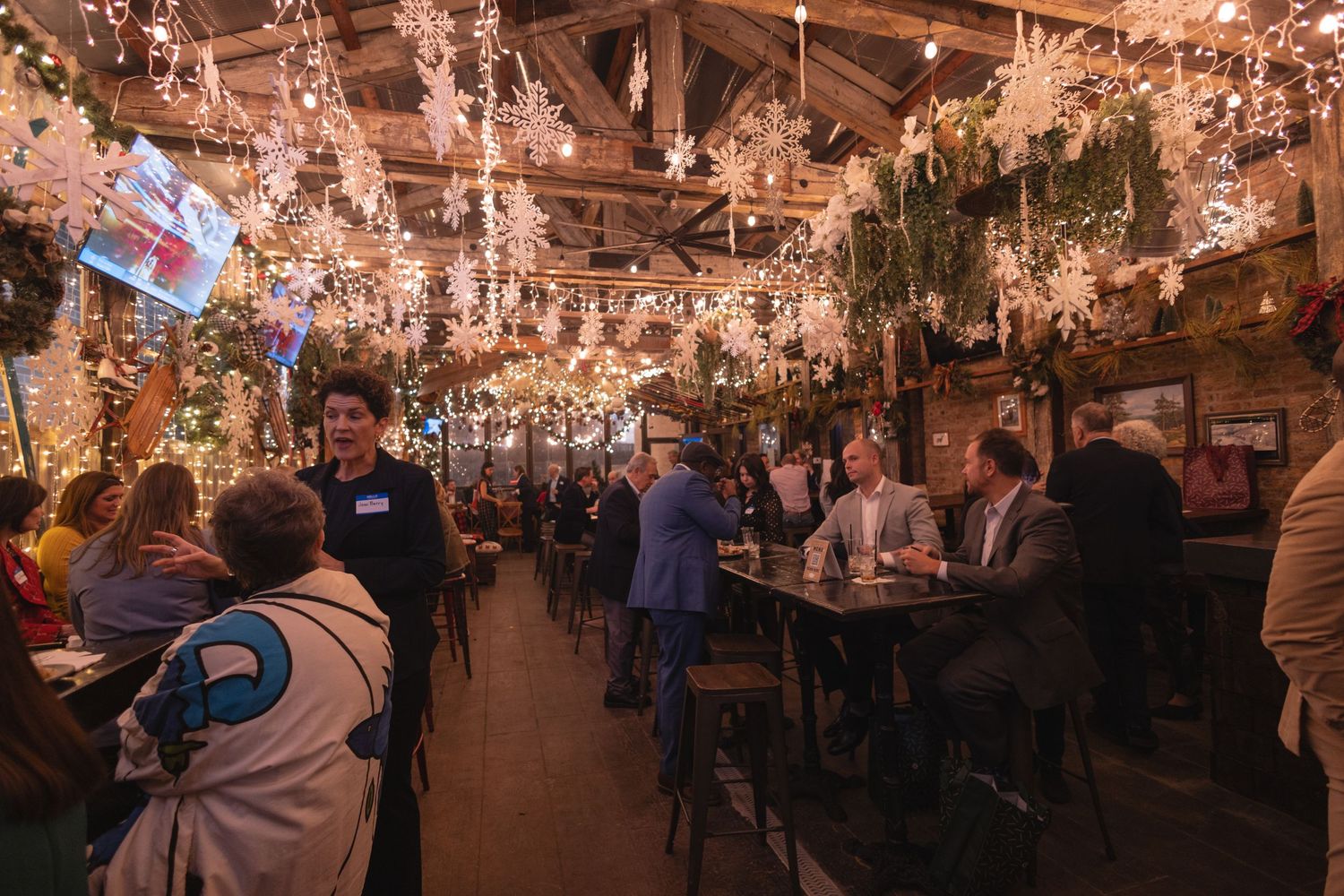 A crowded restaurant bar decorated with twinkling string lights creating a warm, festive atmosphere.