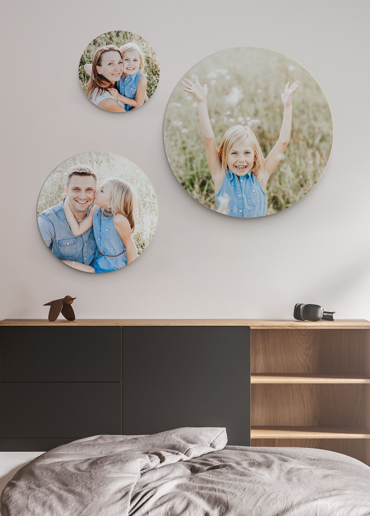Drei kreisförmige Fotoabzüge über dem dunklen Holzkopfteil im Schlafzimmer.