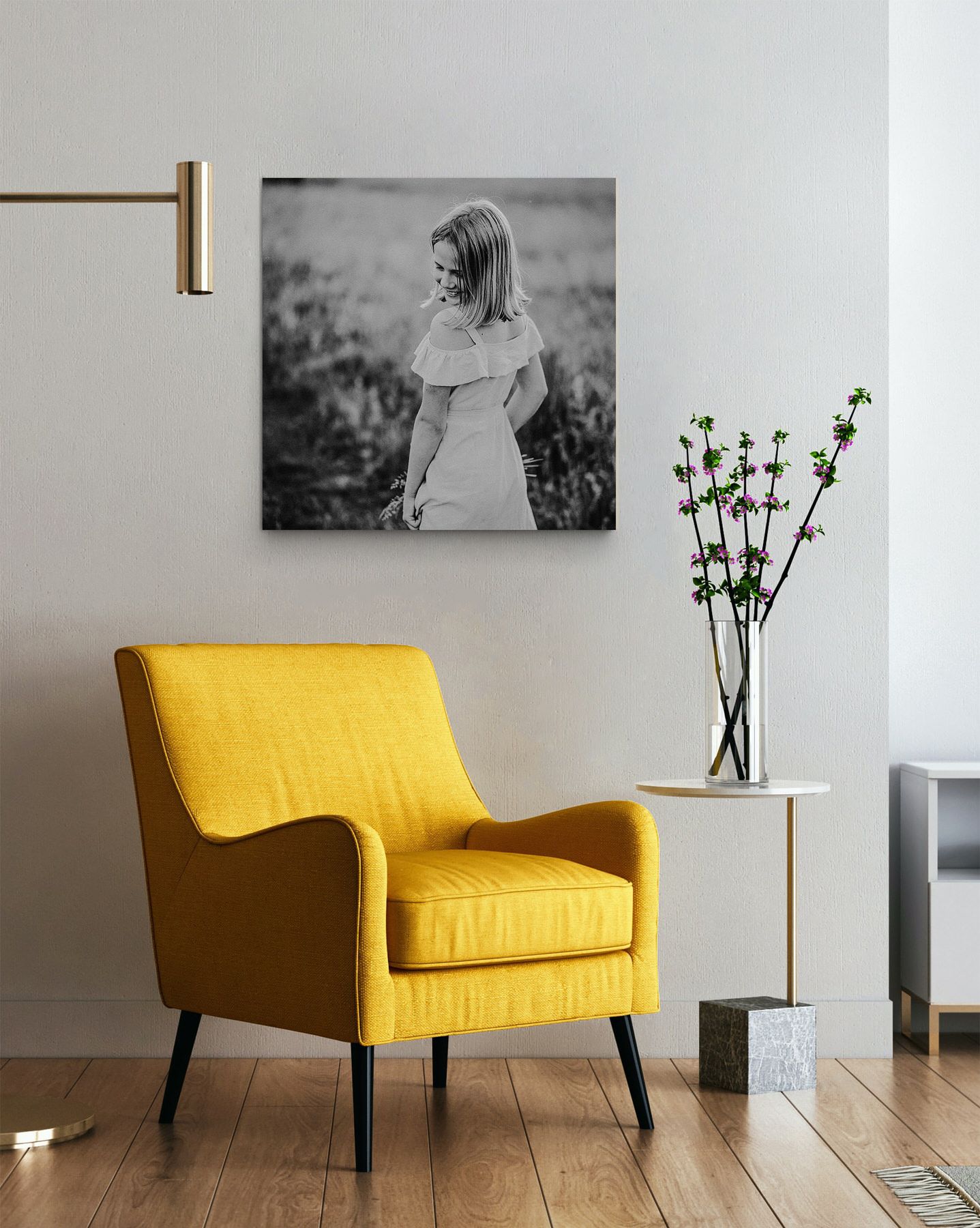 Moderne Wohnzimmerecke mit leuchtend gelbem Akzentstuhl und schwarz-weißer Wandkunst.