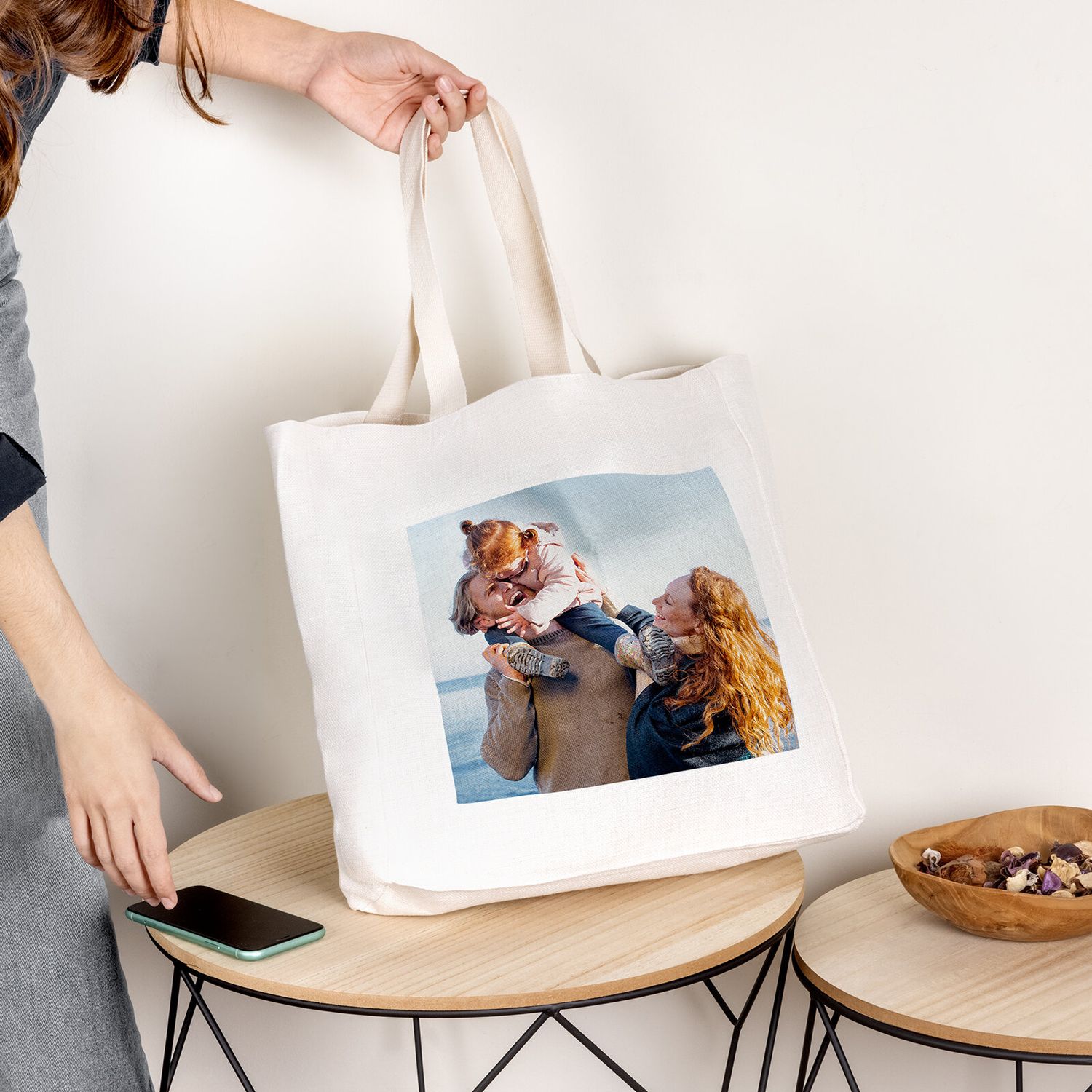 A canvas tote bag with a custom photo print being displayed on a modern side table.