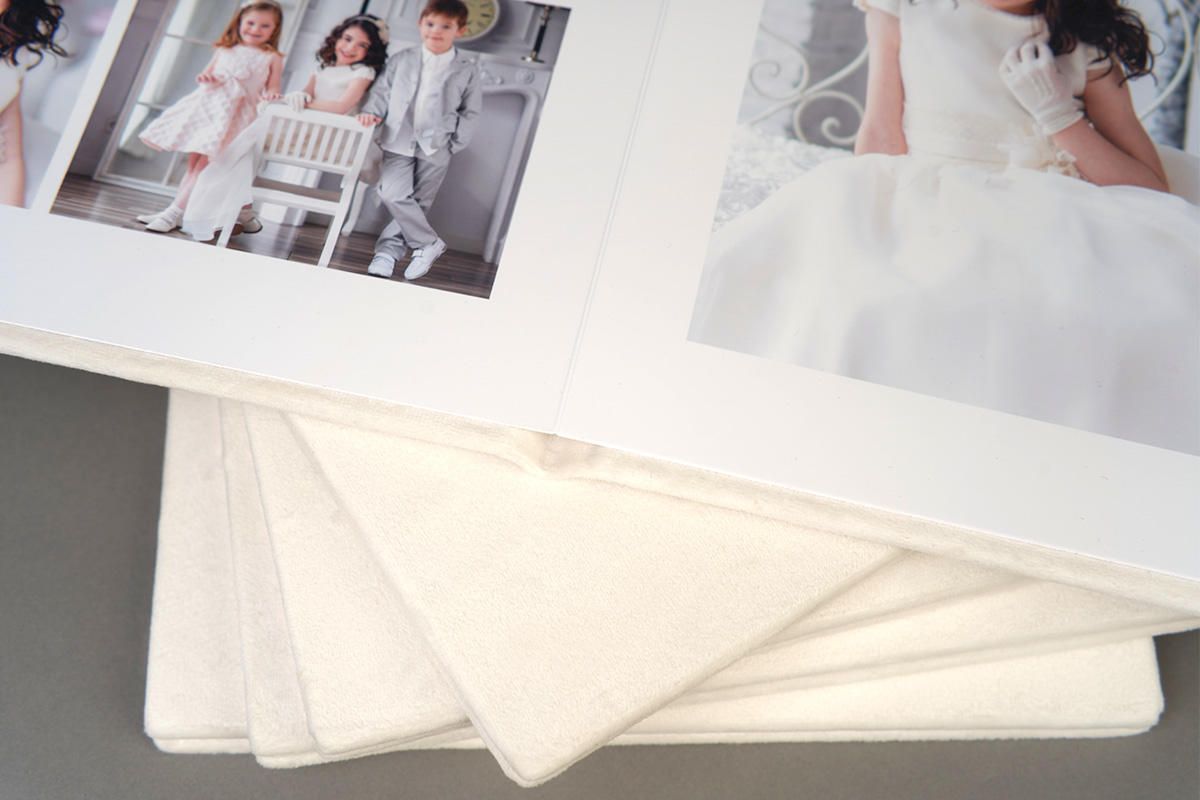 Close-up of white photo album pages showing professional photography spreads.