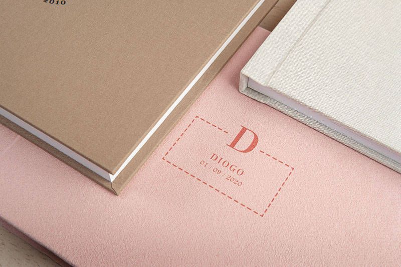 Close-up of premium photo album branding details in pink and neutral tones.