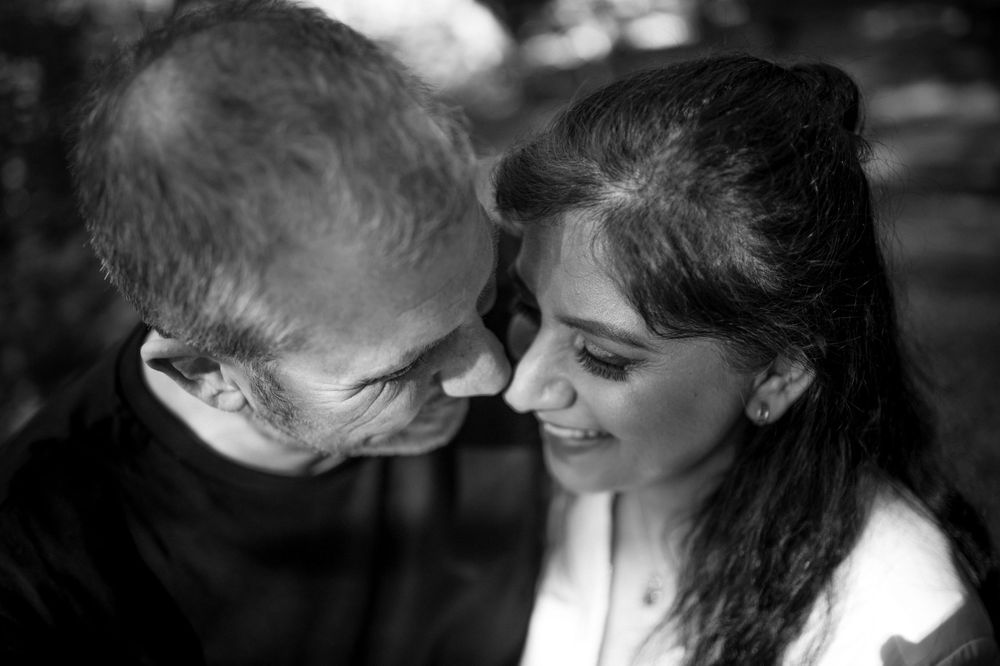 An intimate black and white portrait of a couple sharing a tender moment.