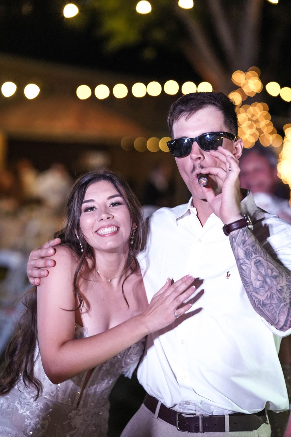 Wedding celebration dance with string lights creating a romantic evening atmosphere.