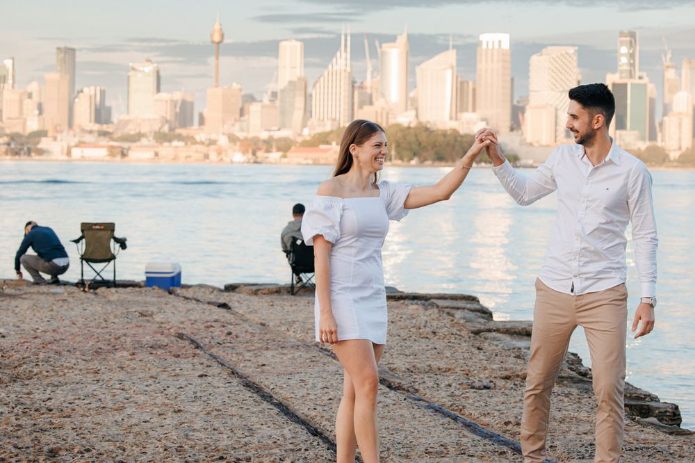 Romantic photoshoot along Sydney Harbour with iconic cityscape in background.