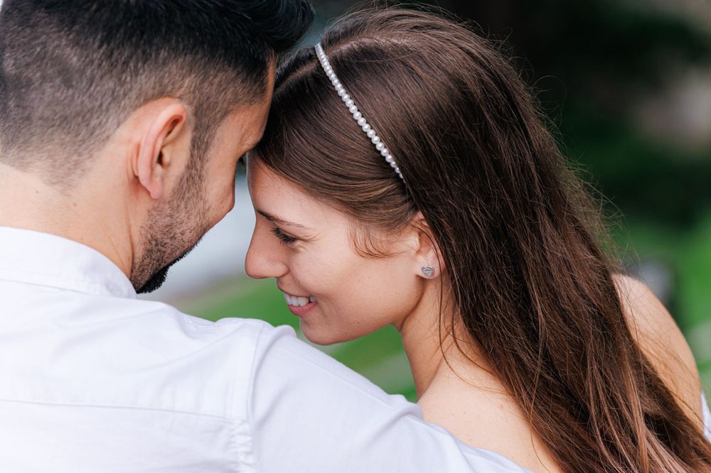 A close-up shot of a couple sharing an intimate moment outdoors.