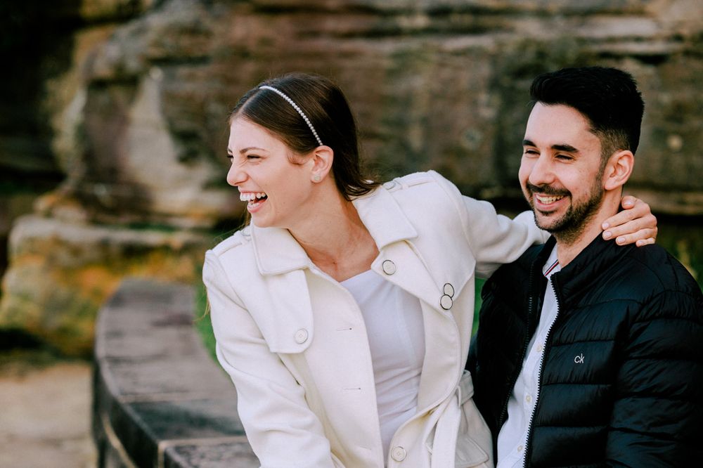 Couple sharing tender moments against a natural outdoor backdrop.