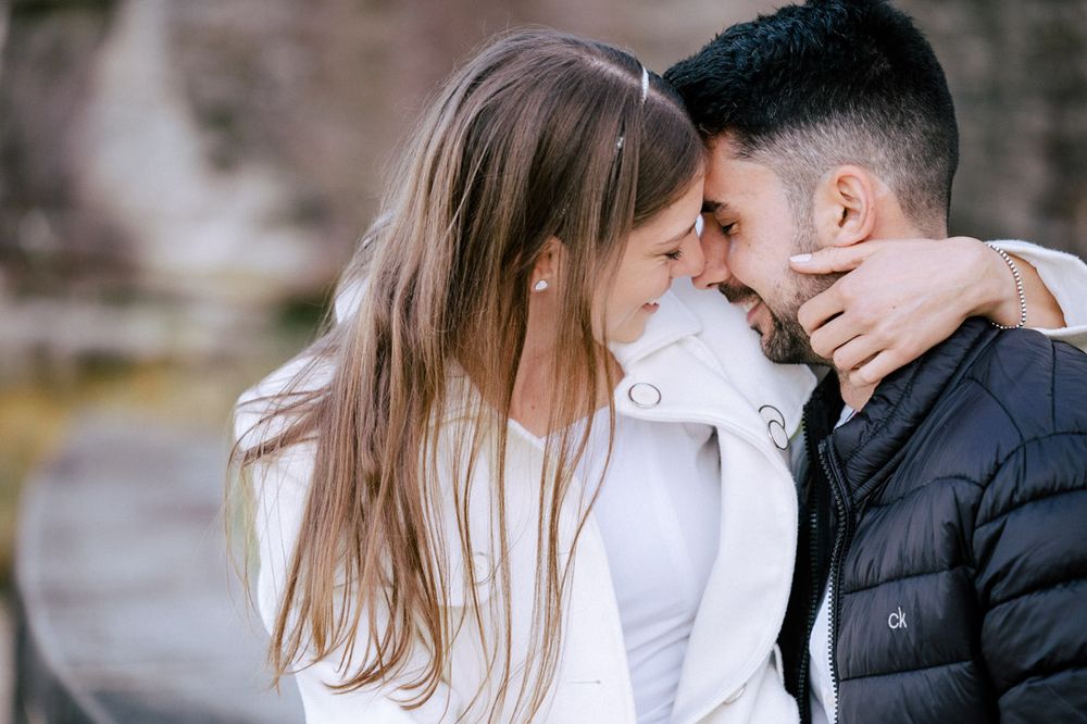 Intimate portrait of a couple embracing outdoors in casual attire.
