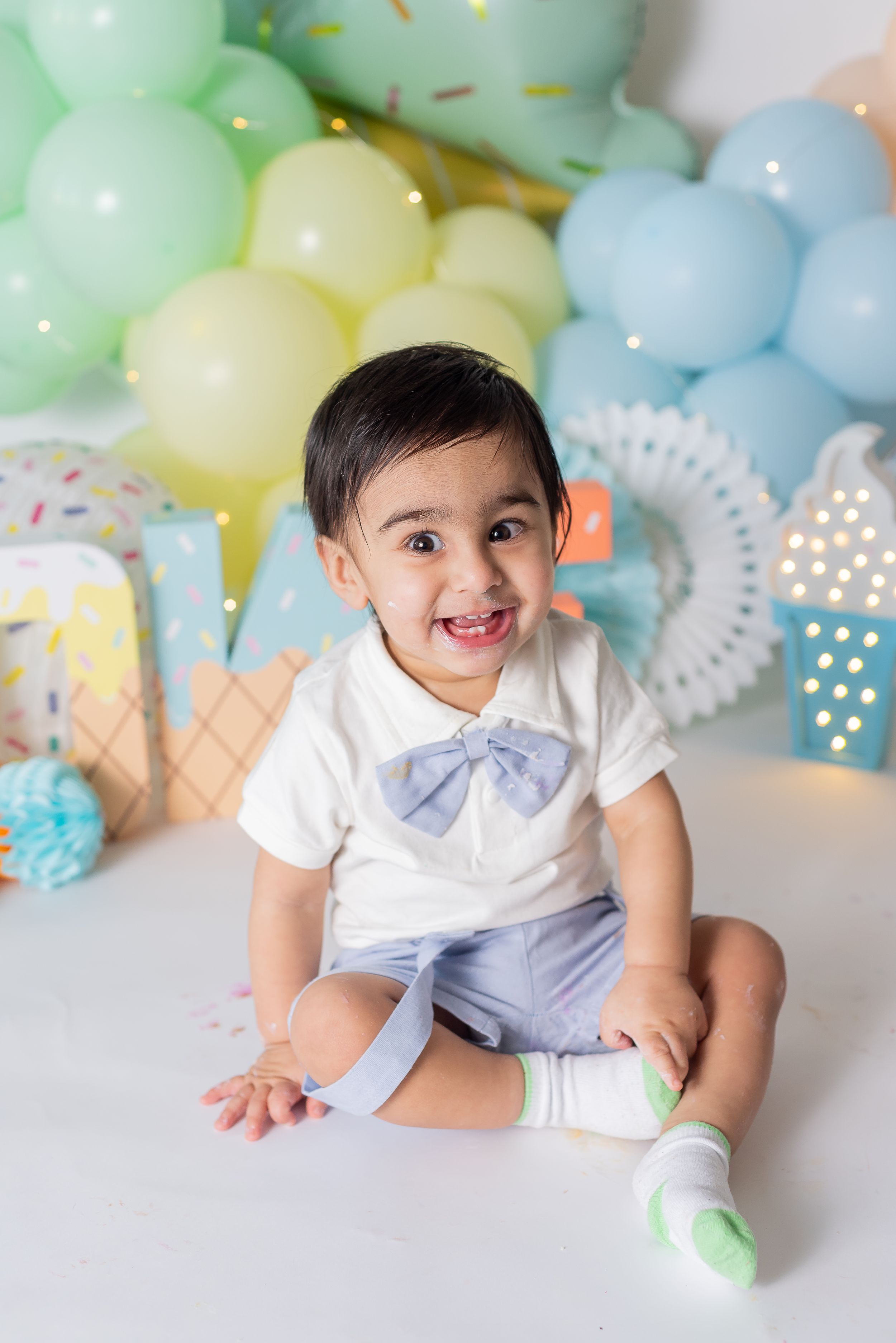 First birthday cake smash session with Lively Ella Photography we can balloons and festive decor.