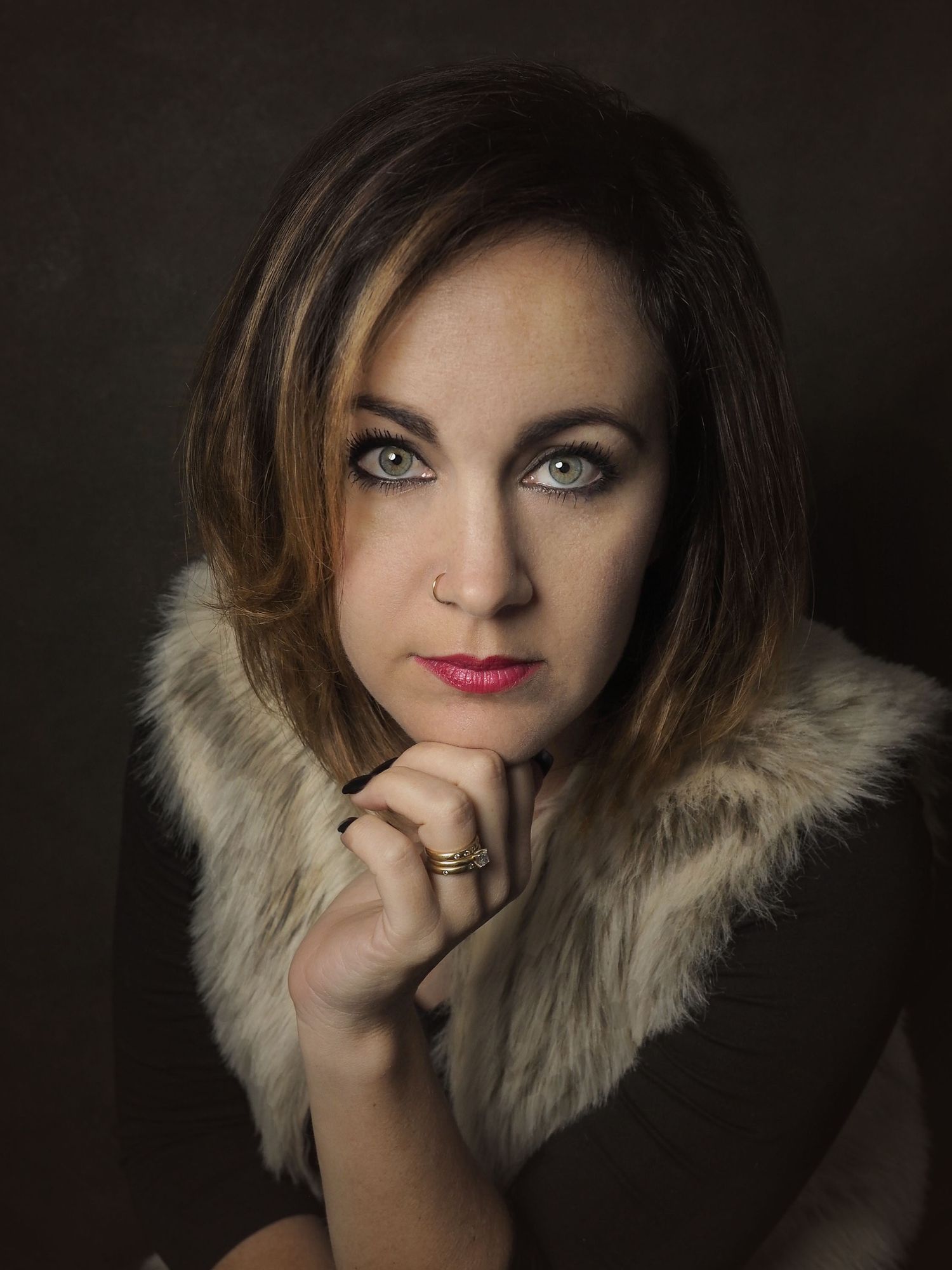 Female with mid length brown hair and green eyes sitting for a portrait