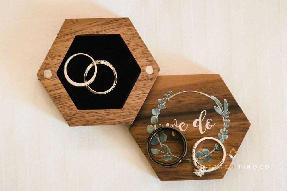 Wedding rings displayed in wooden hexagonal boxes with decorative details.