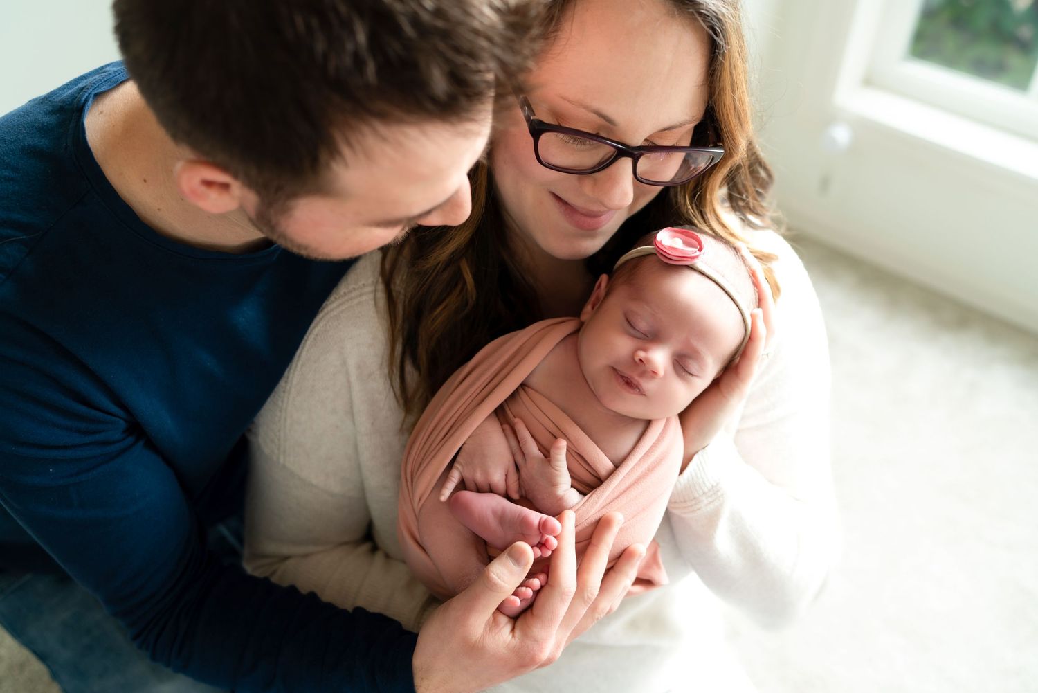 Lifestyle newborn photography session in bright natural window light.