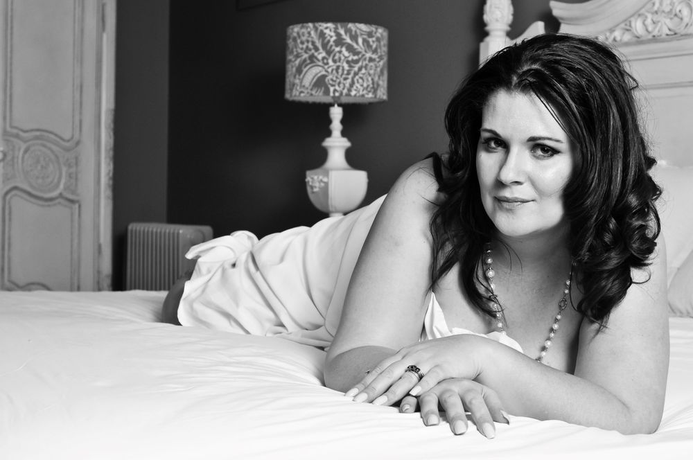 beautiful plus sized lady in her boudoir lying on a bed in sexy nighty in Bryanston