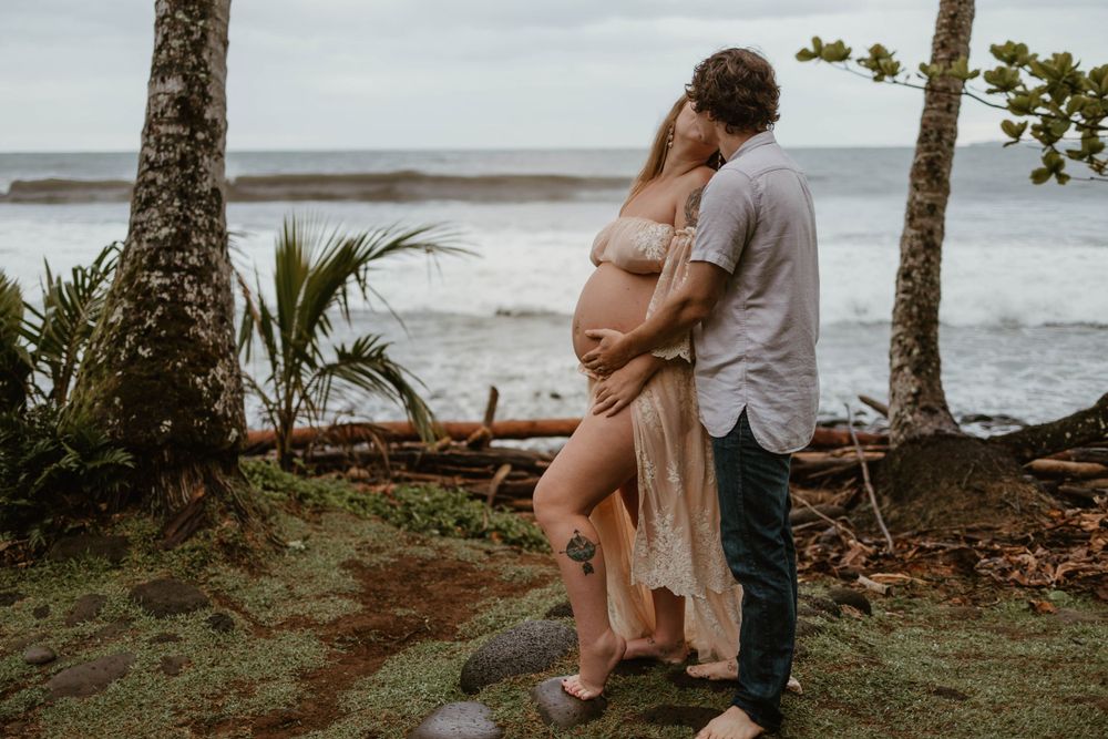 A tender moment between a couple on a tropical beach with palm trees.