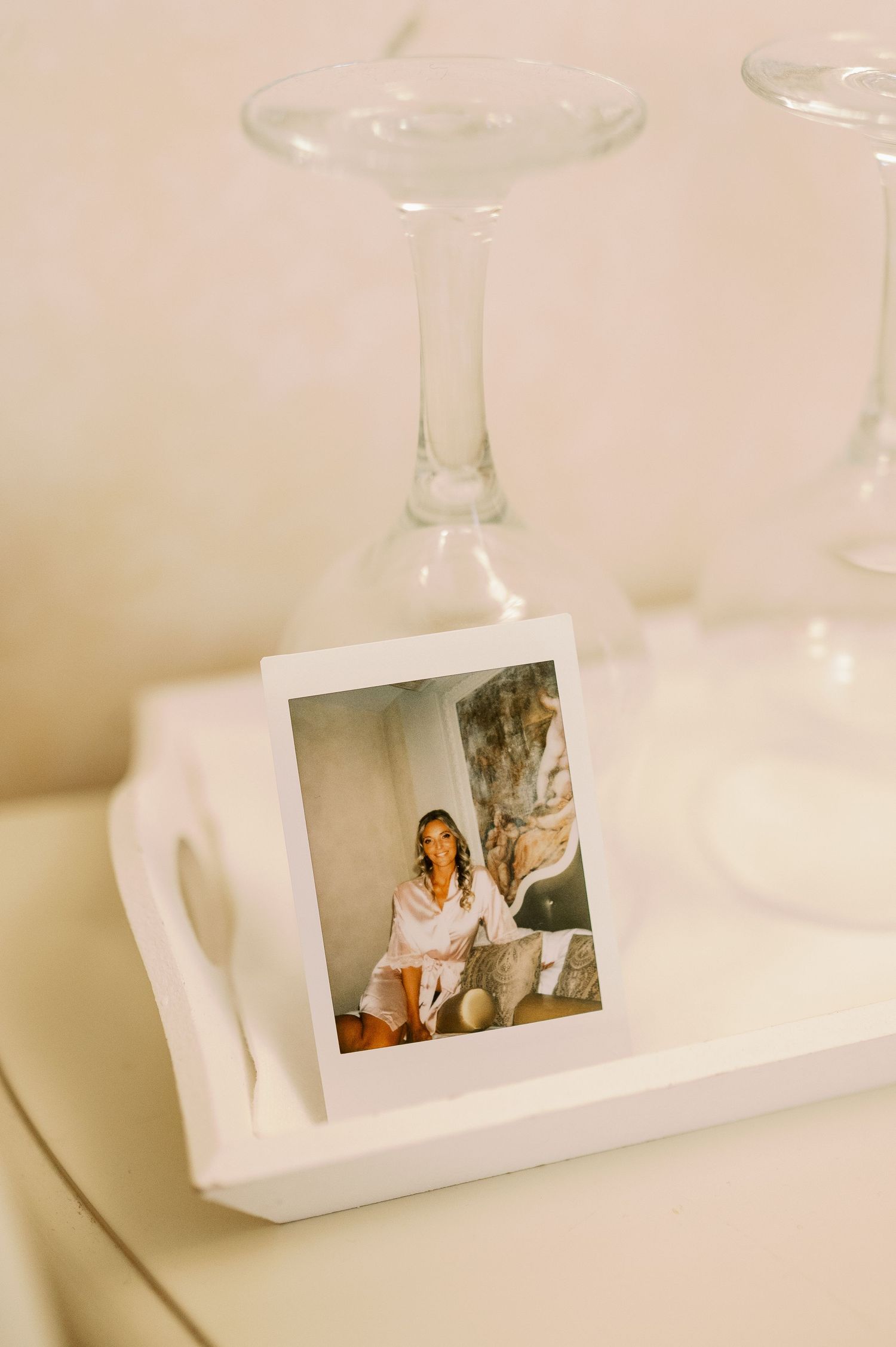A polaroid photo displayed near a wine glass on a white surface.