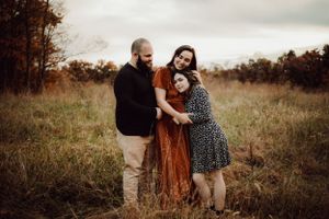Louisville wedding photographer and videographer team, Jenna and Cody Lehman, standing in a field