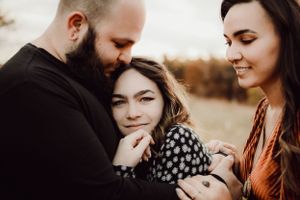 Louisville wedding photographer and videographer team, Jenna and Cody Lehman, standing in a field