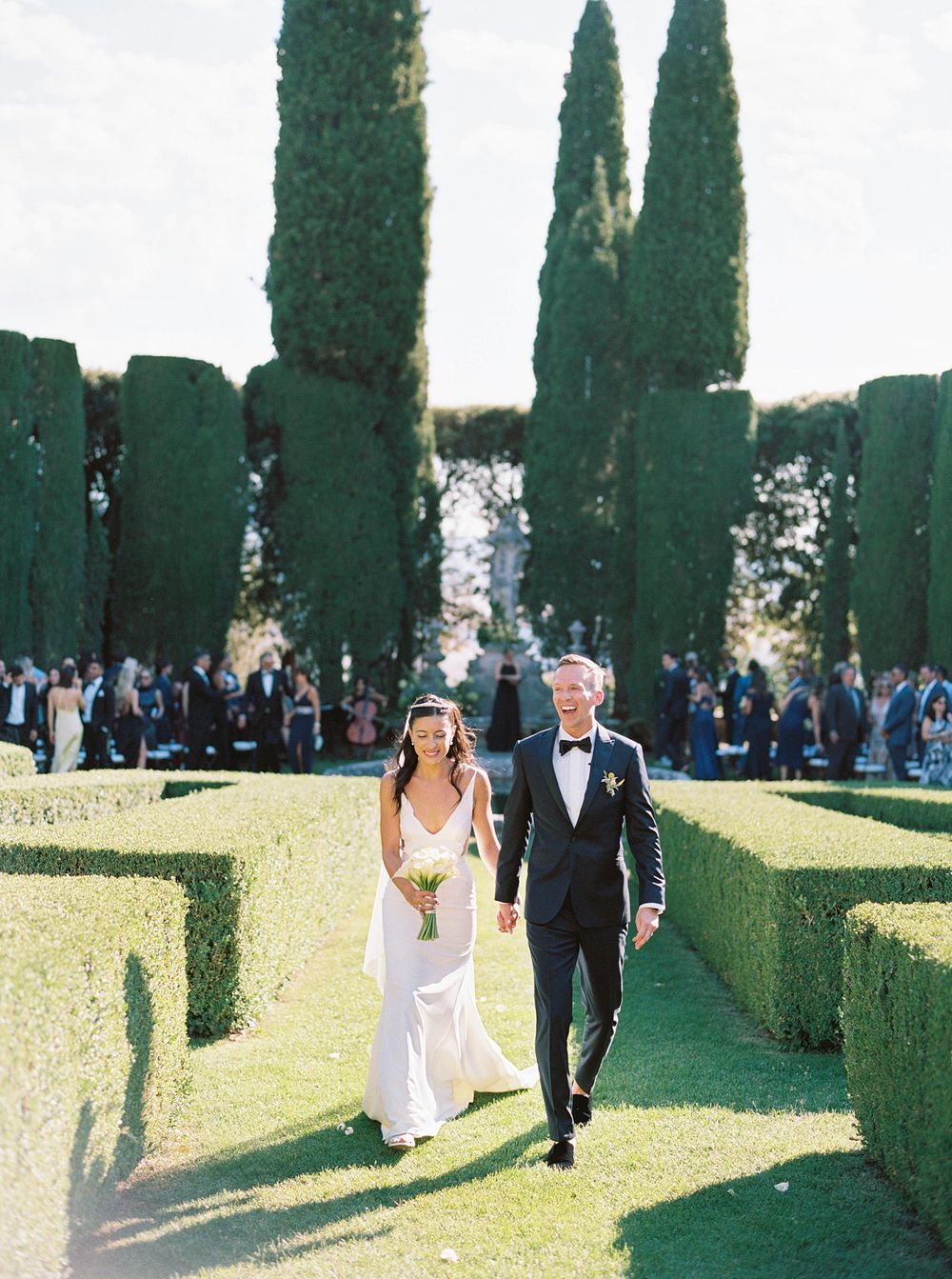 A professional wedding photographer capturing the joyous moment of newlyweds exiting the ceremony in picturesque Tuscany