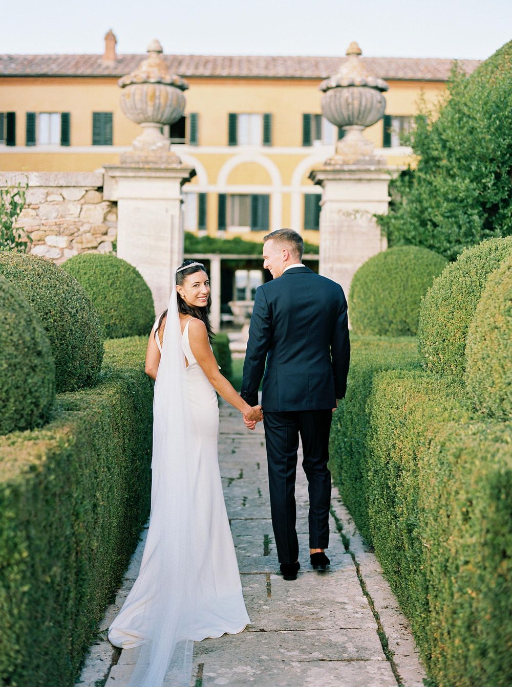A lovely couple, the bride and groom, photographed in the enchanting garden of La Foce, by a wedding photographer.