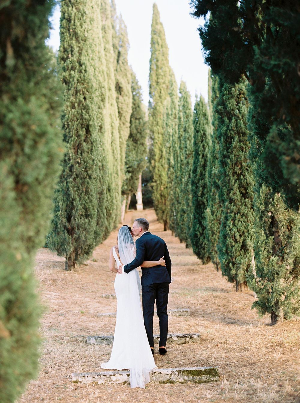 Wedding photographer capturing a beautiful moment of a bride and groom in the scenic backdrop of Tuscany.