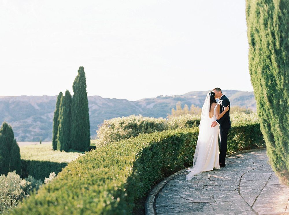 Newlyweds embracing in the picturesque landscape of La Foce, Tuscany.