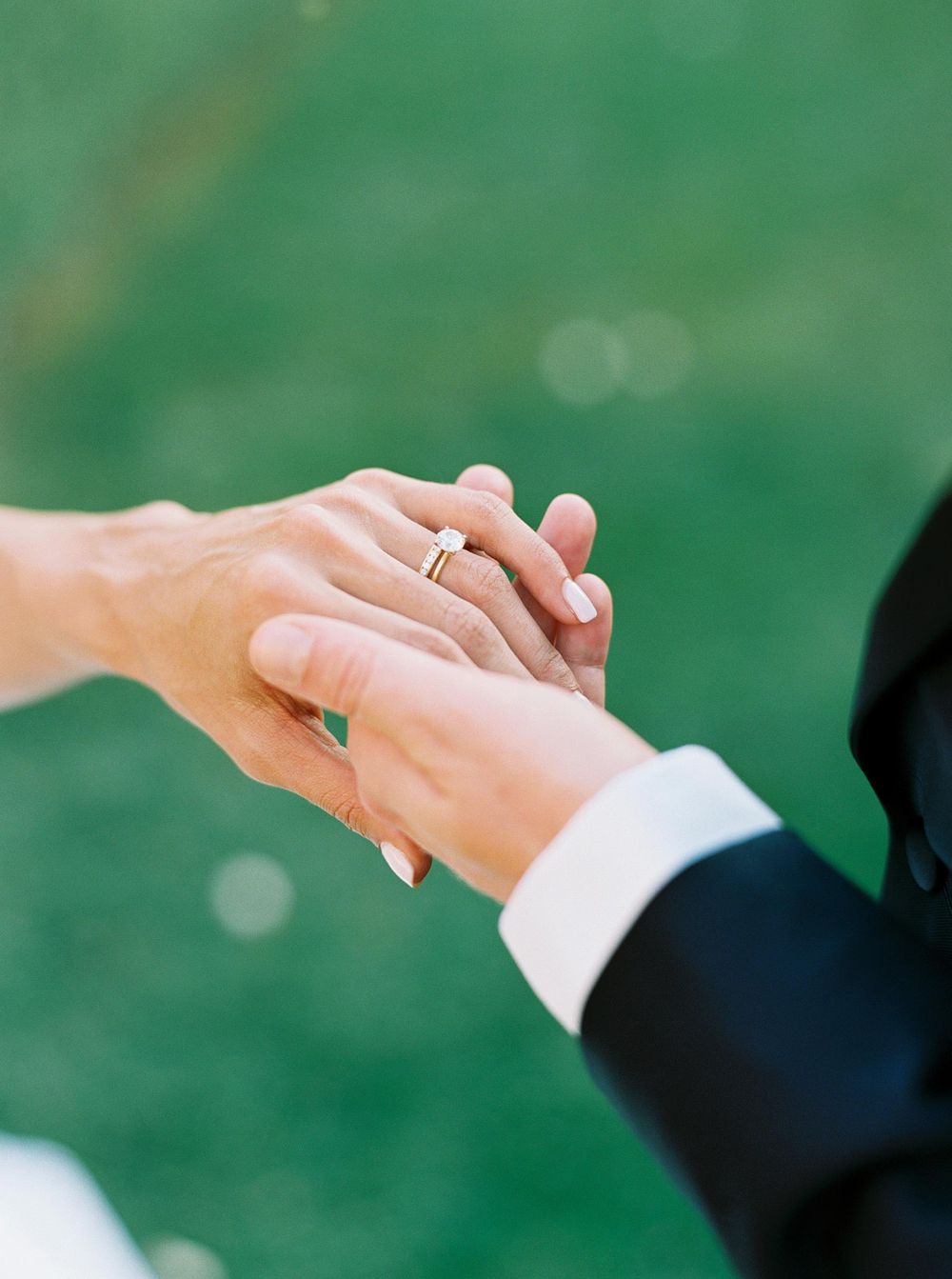 Wedding rings on hands, symbolizing eternal love and commitment.