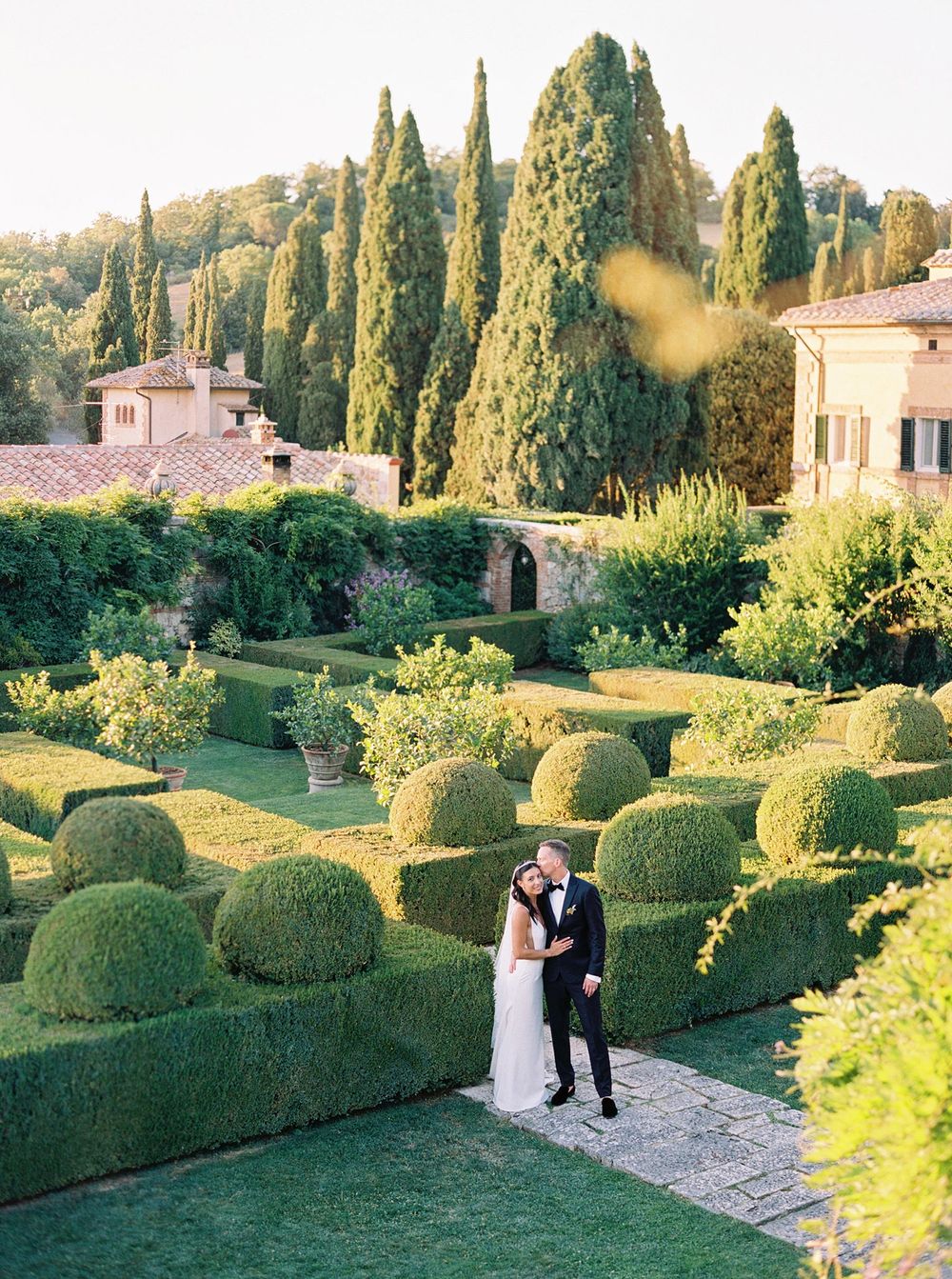 A beautiful wedding in Tuscany, Italy. The bride and groom posing in the garden at La Foce.