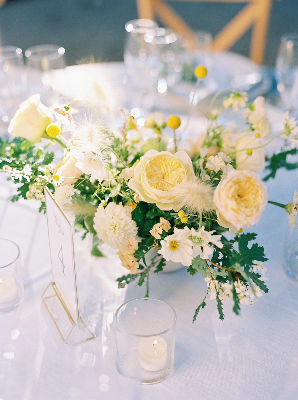 Table setting with white flowers and greenery in La Foce, Tuscany.