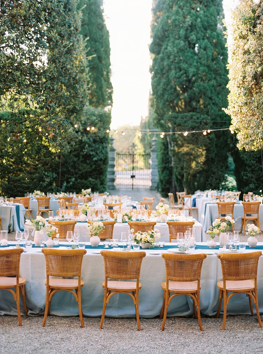 Outdoor wedding reception with tables and chairs in La Foce, Tuscany. A picturesque celebration amidst nature's beauty.