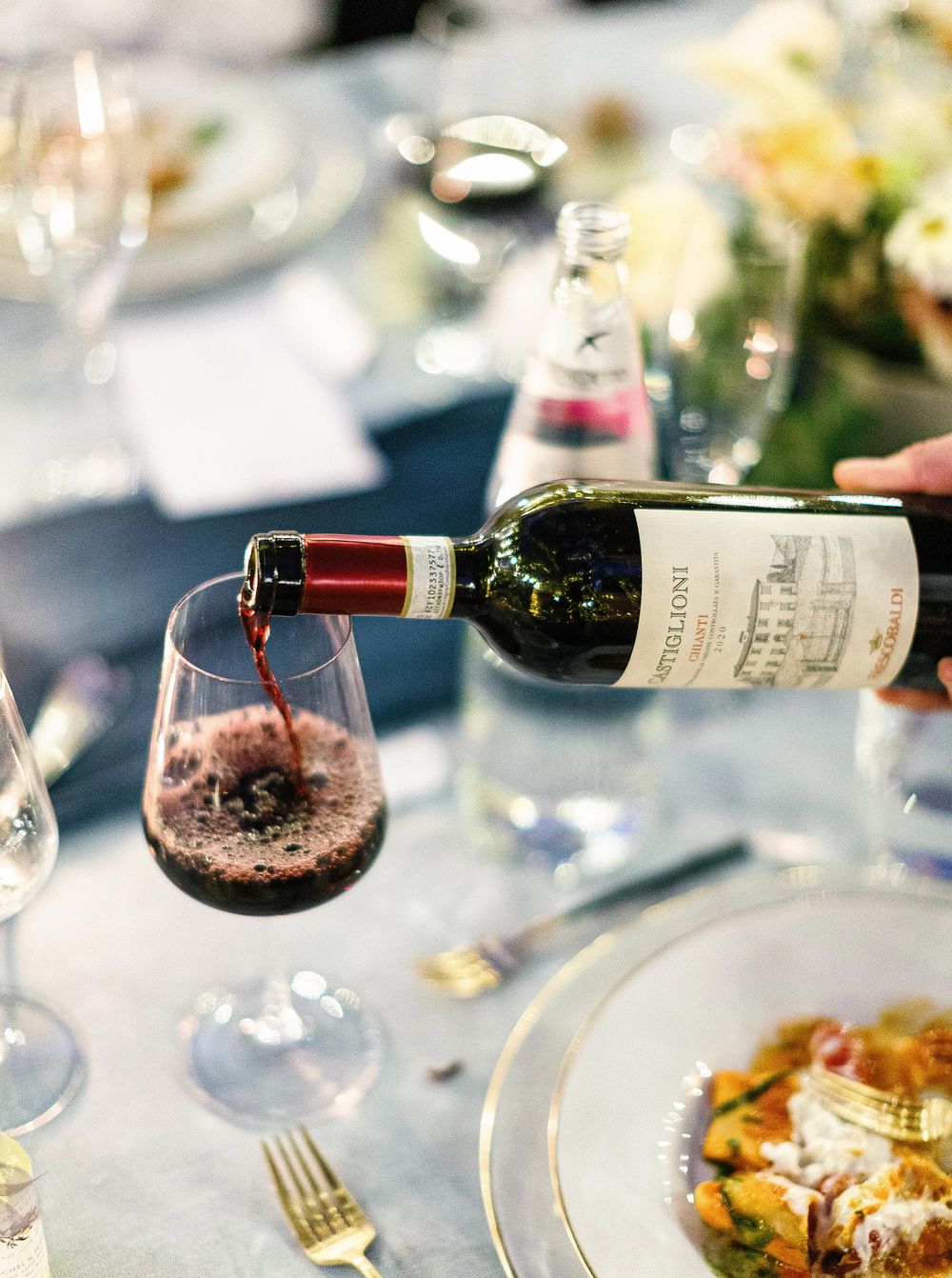 Tuscany wedding scene: pouring wine into a glass.