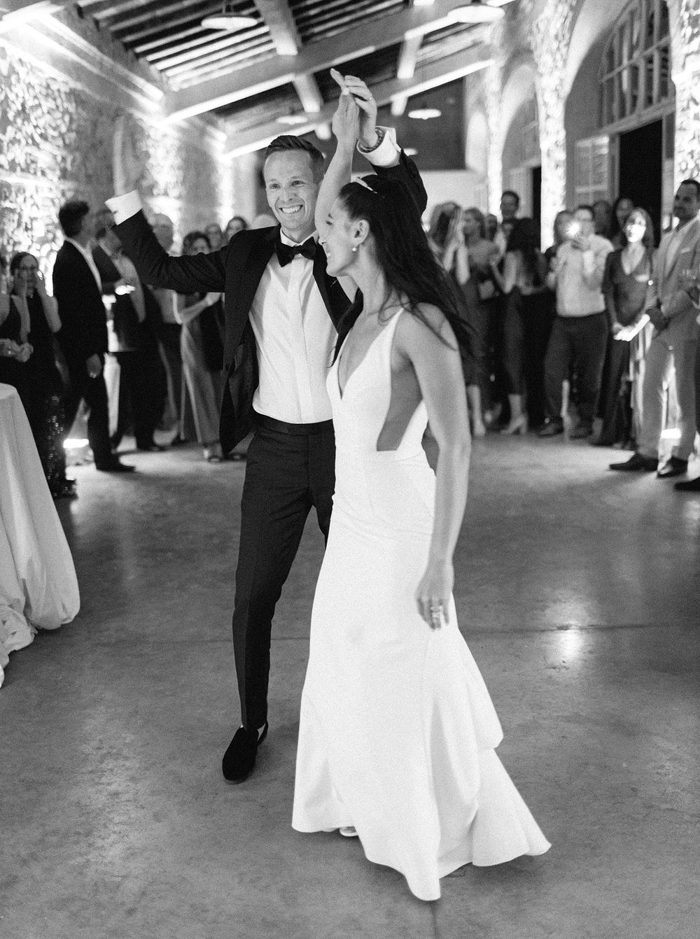 A couple gracefully dancing at their wedding in La Foce, Tuscany.