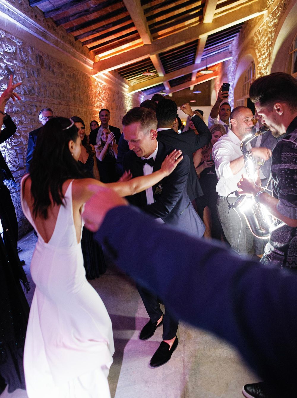 A bride and groom joyfully dancing together during their wedding reception in La Foce, Tuscany.