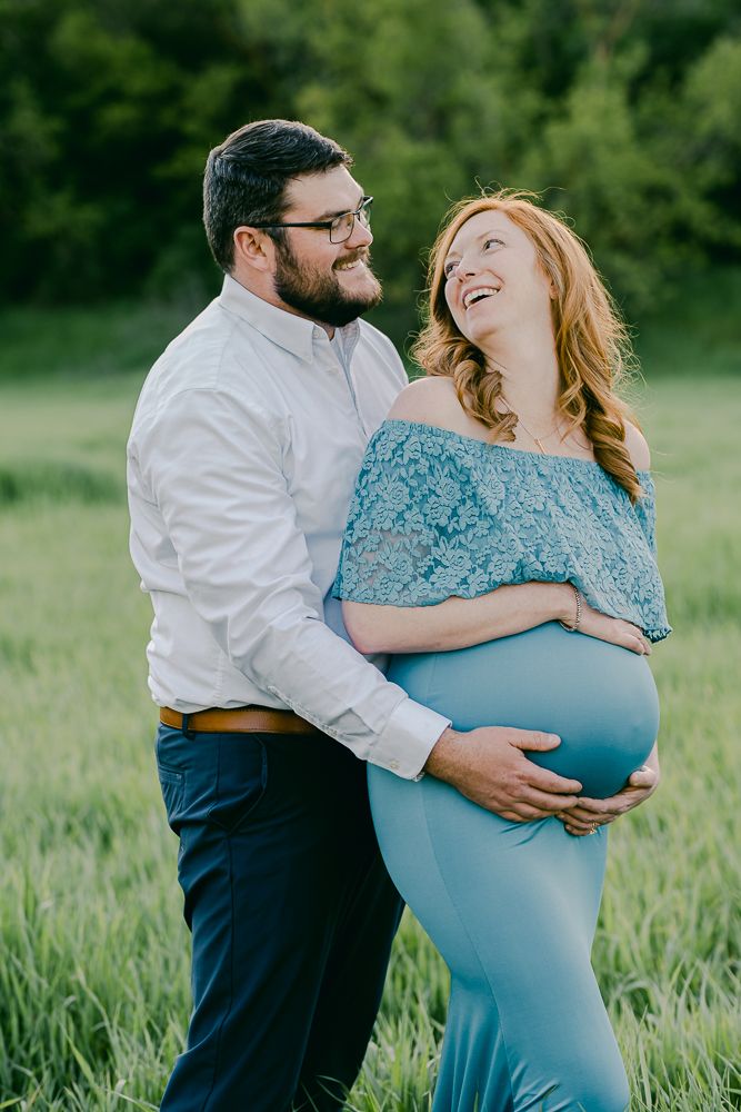 Ashley is wearing a blue maternity dress outside with her husband in Salt Lake City, Utah.