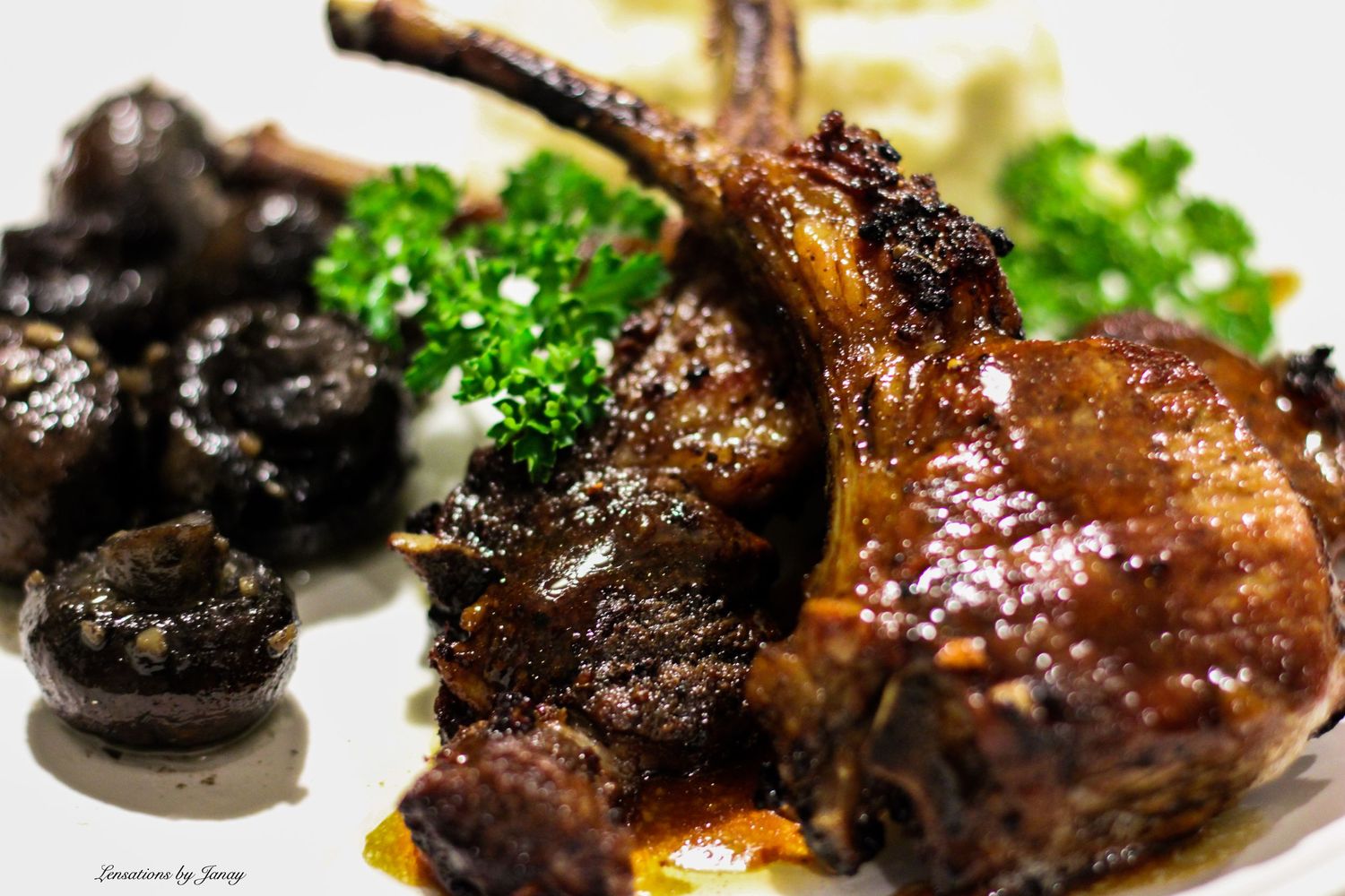 Glazed duck confit with roasted mushrooms and fresh parsley garnish on a white plate.