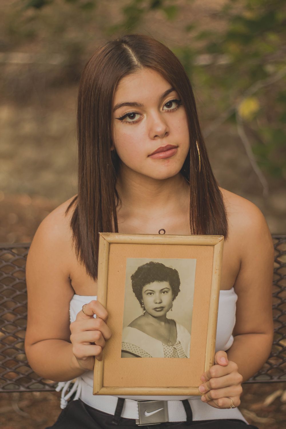 Portrait style photo shoot with vintage framed photograph against natural background.