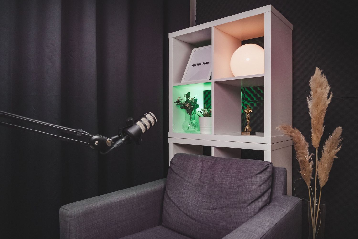 Recording studio interior with dark acoustic panels and modern furniture setup.