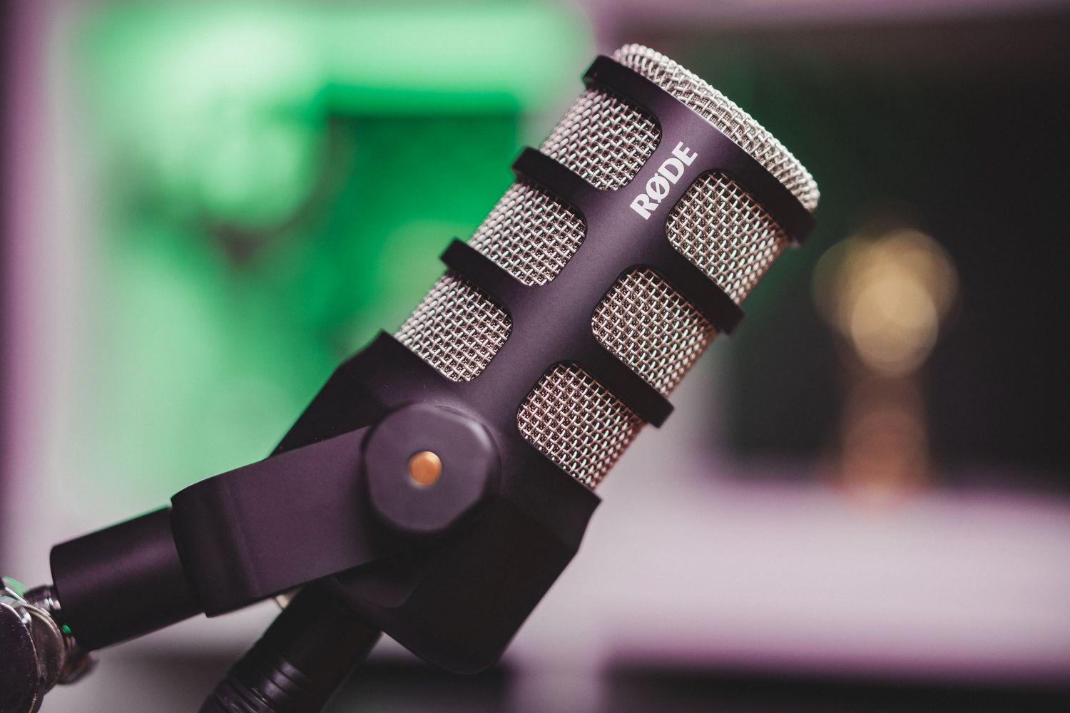 Professional microphone setup with green ambient lighting in recording studio.