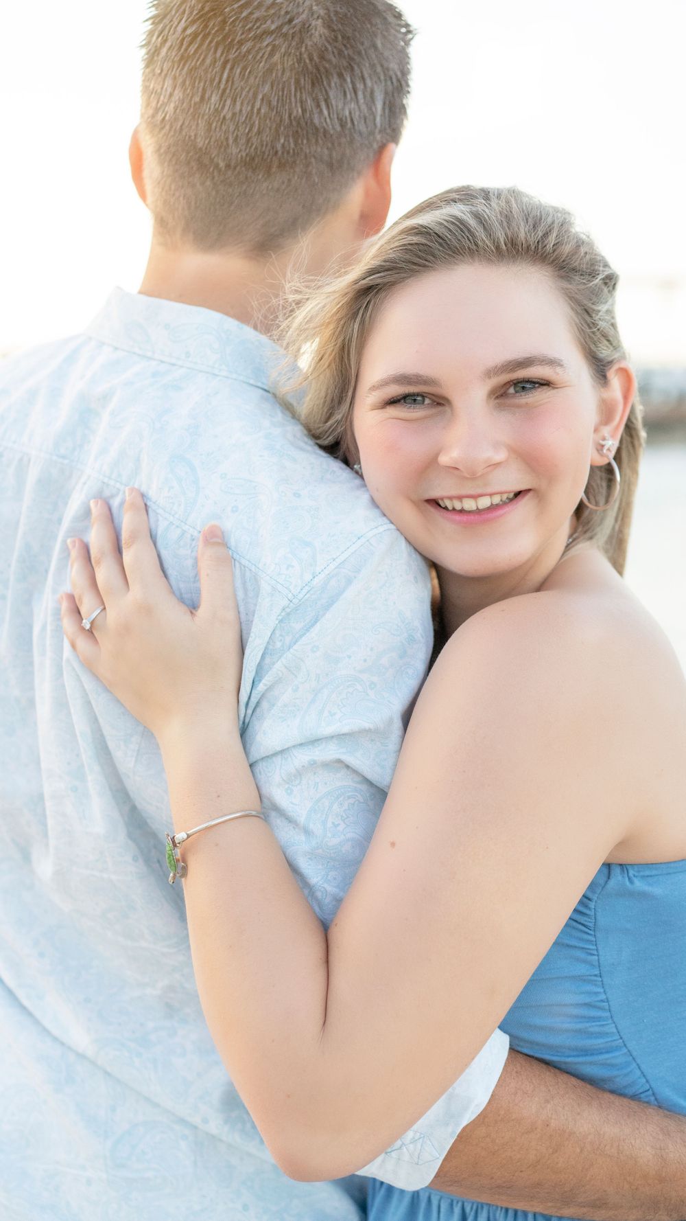 Intimate portrait of couple embracing outdoors in casual attire.