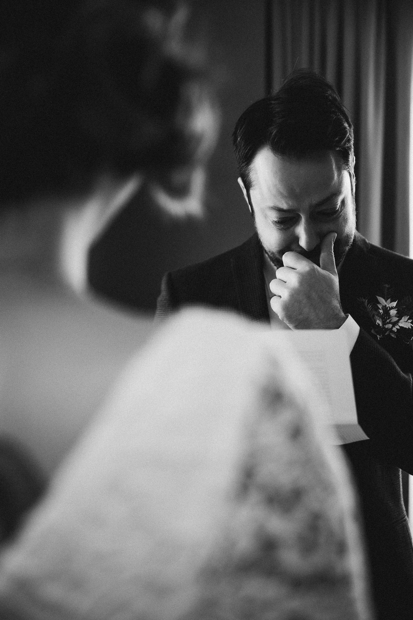 An emotional black and white wedding moment captured during ceremony vows.