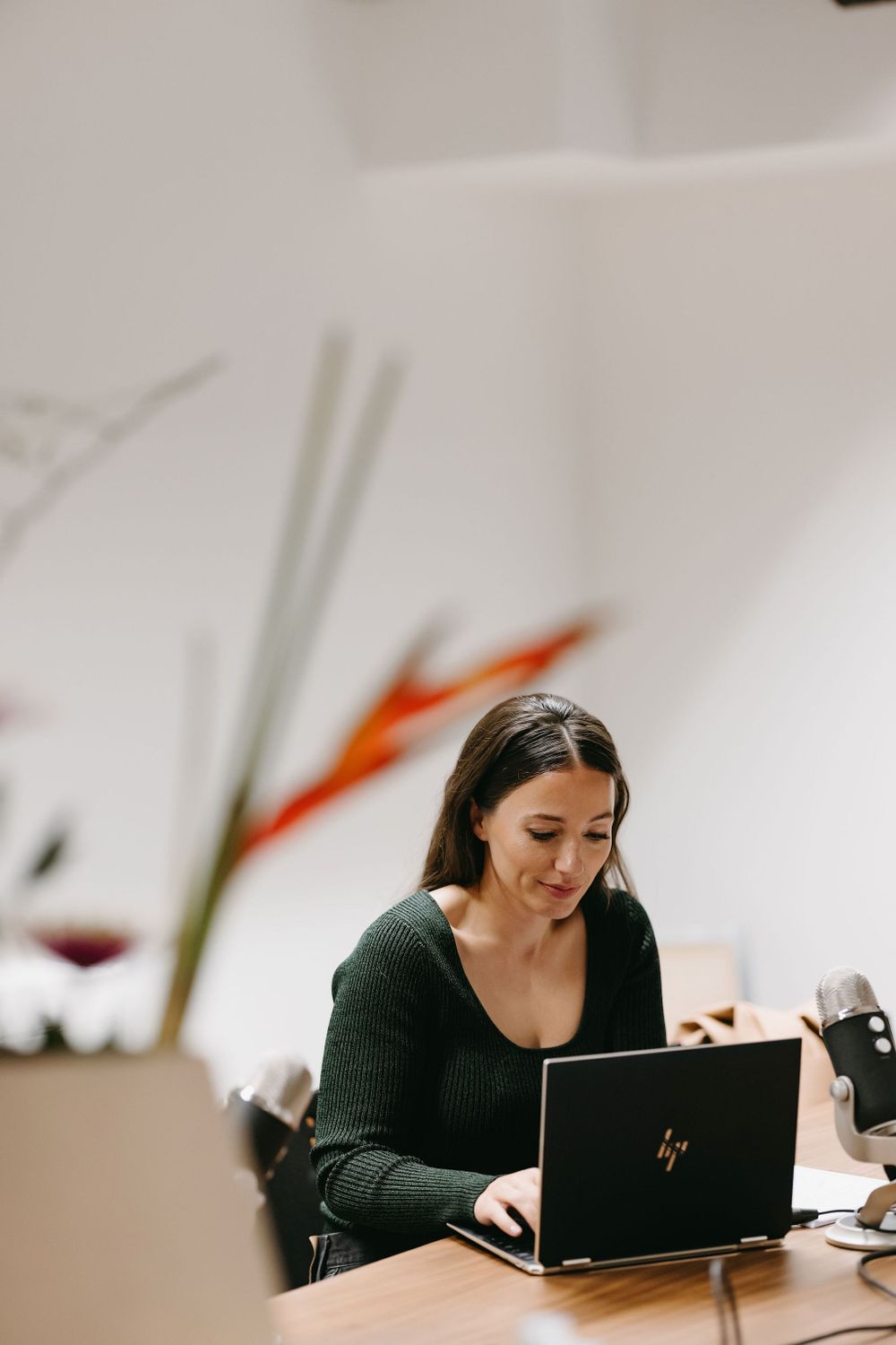 Person working on HP laptop in minimalist office setting.